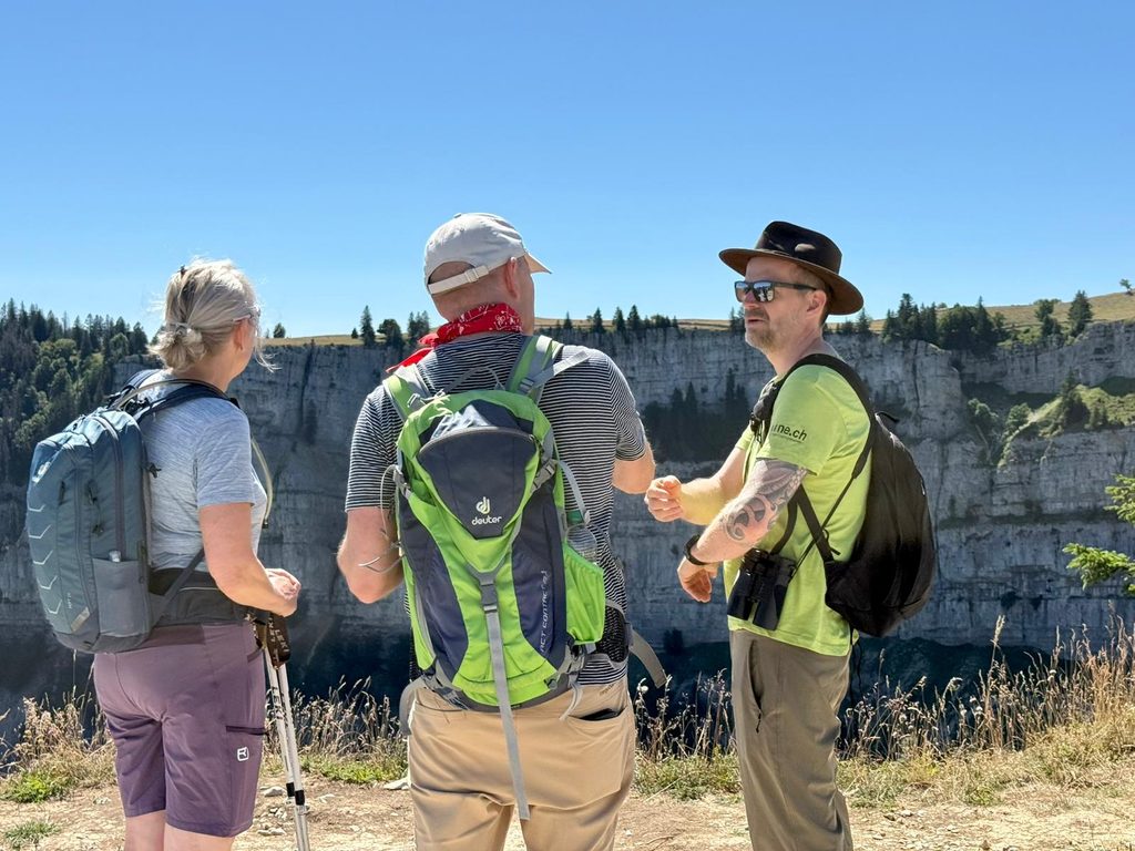 Ranger sensibilisant des visiteurs au Creux du Van