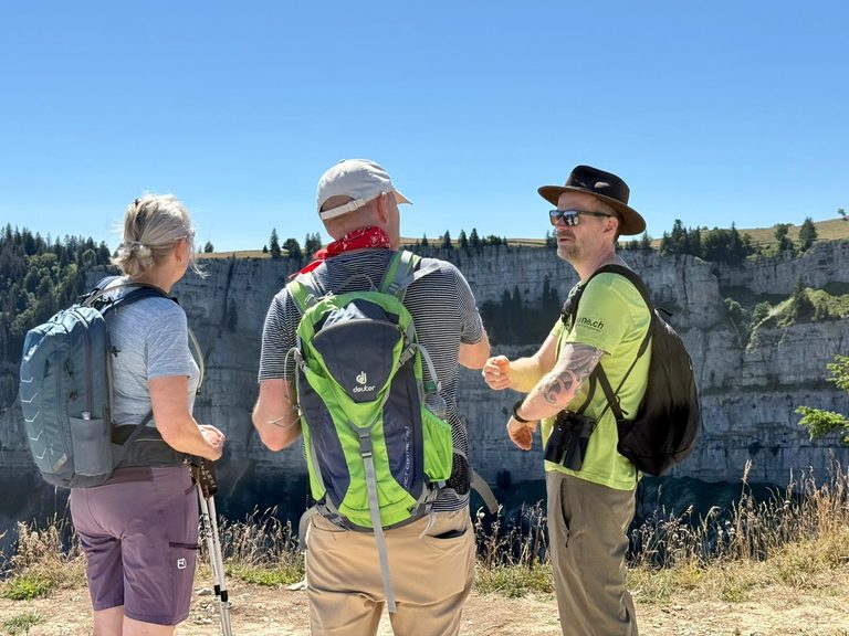 Ranger sensibilisant des visiteurs au Creux du Van